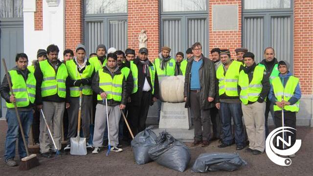 Vrijwilligers Ahmadiyya moslimgemeenschap vegen in Kasterlee dorpsplein schoon
